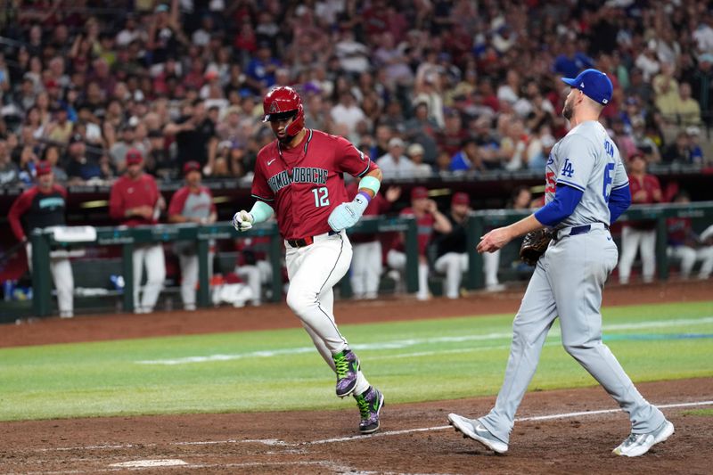 Apr 29, 2024; Phoenix, Arizona, USA; Arizona Diamondbacks outfielder Lourdes Gurriel Jr. (12) scores a run after a wild pitch during the fifth inning against the Los Angeles Dodgers at Chase Field. Mandatory Credit: Joe Camporeale-USA TODAY Sports