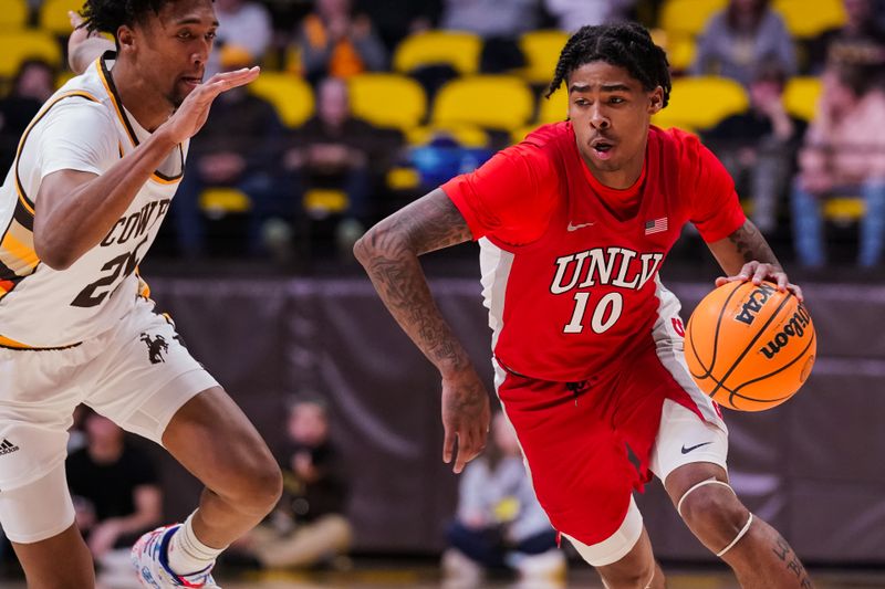 Feb 8, 2023; Laramie, Wyoming, USA; UNLV Runnin' Rebels guard Keshon Gilbert (10) drives against Wyoming Cowboys forward Jeremiah Oden (25) during the second half at Arena-Auditorium. Mandatory Credit: Troy Babbitt-USA TODAY Sports