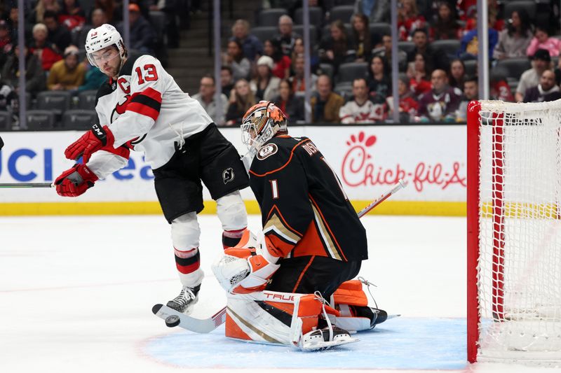 Mar 1, 2024; Anaheim, California, USA; Anaheim Ducks goaltender Lukas Dostal (1) blocks a shot by New Jersey Devils center Nico Hischier (13) during the third period at Honda Center. Mandatory Credit: Kiyoshi Mio-USA TODAY Sports