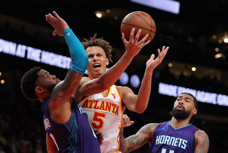 ATLANTA, GEORGIA - OCTOBER 25:  Dyson Daniels #5 of the Atlanta Hawks scores as he drives against Miles Bridges #0 of the Charlotte Hornets during the fourth quarter at State Farm Arena on October 25, 2024 in Atlanta, Georgia.  NOTE TO USER: User expressly acknowledges and agrees that, by downloading and/or using this photograph, user is consenting to the terms and conditions of the Getty Images License Agreement.  (Photo by Kevin C. Cox/Getty Images)