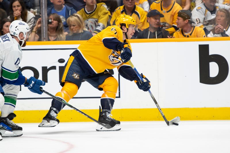 Apr 28, 2024; Nashville, Tennessee, USA; Nashville Predators left wing Anthony Beauvillier (21) passes the puck against the Vancouver Canucks during the second period in game four of the first round of the 2024 Stanley Cup Playoffs at Bridgestone Arena. Mandatory Credit: Steve Roberts-USA TODAY Sports