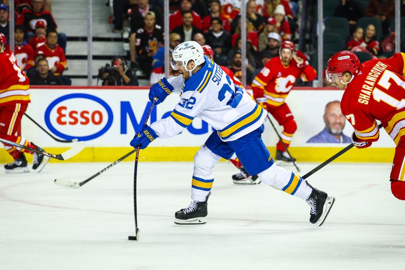 Oct 11, 2025; Calgary, Alberta, CAN; St. Louis Blues center Pius Suter (22) shoots the puck against the Calgary Flames during the third period at Scotiabank Saddledome. Mandatory Credit: Sergei Belski-Imagn Images