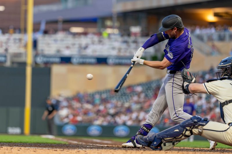 Jun 11, 2024; Minneapolis, Minnesota, USA; Colorado Rockies third baseman Ryan McMahon (24) hits a solo home run against the Minnesota Twins in the eighth inning at Target Field. Mandatory Credit: Jesse Johnson-USA TODAY Sports