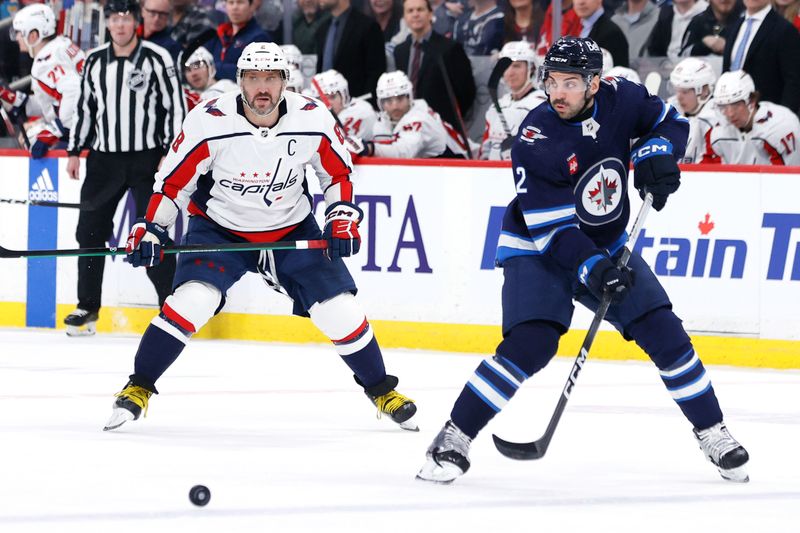 Mar 11, 2024; Winnipeg, Manitoba, CAN; Winnipeg Jets defenseman Dylan DeMelo (2) makes pass in the first period in front of Washington Capitals left wing Alex Ovechkin (8) at Canada Life Centre. Mandatory Credit: James Carey Lauder-USA TODAY Sports