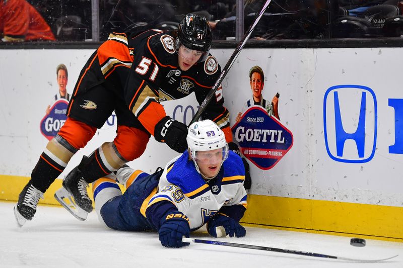 Apr 7, 2024; Anaheim, California, USA; Anaheim Ducks defenseman Olen Zellweger (51) plays for the puck against St. Louis Blues center Nikita Alexandrov (59) during the first period at Honda Center. Mandatory Credit: Gary A. Vasquez-USA TODAY Sports