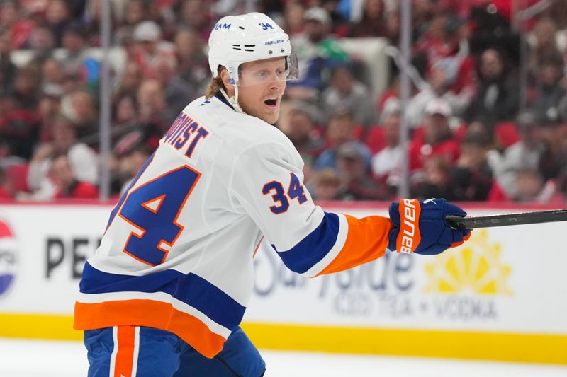 Oct 30, 2025; Raleigh, North Carolina, USA;  New York Islanders defenseman Adam Boqvist (34) takes a shot against the Carolina Hurricanes during the second period at Lenovo Center. Mandatory Credit: James Guillory-Imagn Images