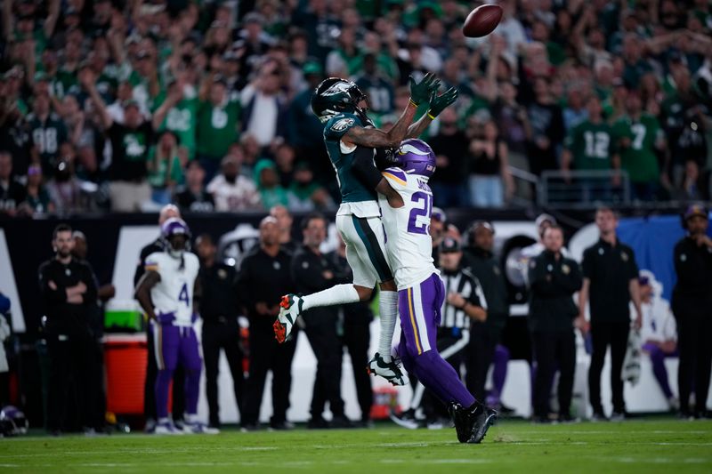 Philadelphia Eagles wide receiver DeVonta Smith (6) reaches for the ball in front of Minnesota Vikings safety Theo Jackson (25) during the first half of an NFL football game Thursday, Sept. 14, 2023, in Philadelphia. (AP Photo/Matt Slocum)