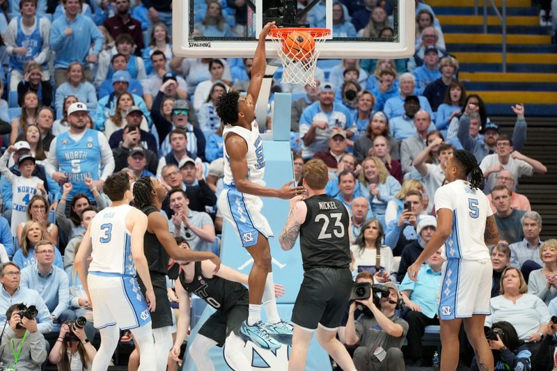 Feb 17, 2024; Chapel Hill, North Carolina, USA; North Carolina Tar Heels forward Harrison Ingram (55) scores as Virginia Tech Hokies guard Hunter Cattoor (0) and guard Tyler Nickel (23) defend in the first half at Dean E. Smith Center. Mandatory Credit: Bob Donnan-USA TODAY Sports