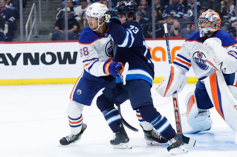 Sep 25, 2024; Winnipeg, Manitoba, CAN; Winnipeg Jets goalie Arvid Holm (75) jostles for position with Edmonton Oilers defenseman Max Wanner (88) in front of Edmonton Oilers goalie Stuart Skinner (74) during the second period at Canada Life Centre. Mandatory Credit: Terrence Lee-Imagn Images