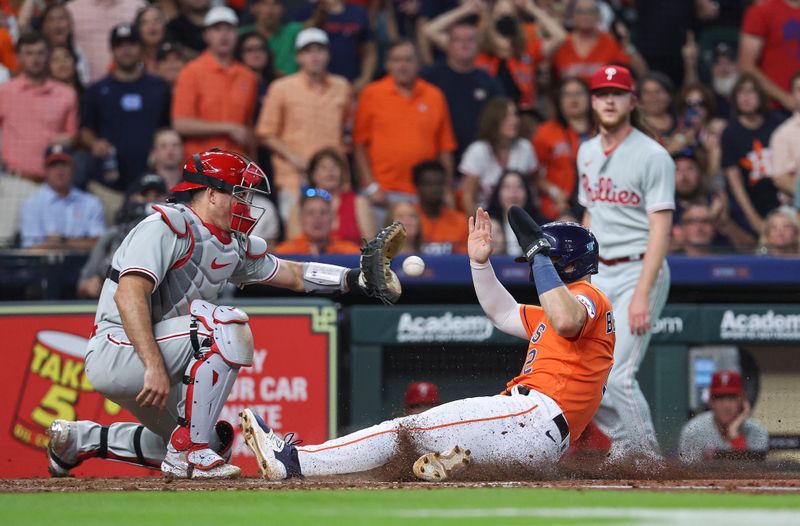 Apr 30, 2023; Houston, Texas, USA; Houston Astros third baseman Alex Bregman (2) slides safely to score a run as Philadelphia Phillies catcher J.T. Realmuto (10) attempts to field the throw during the fifth inning at Minute Maid Park. Mandatory Credit: Troy Taormina-USA TODAY Sports