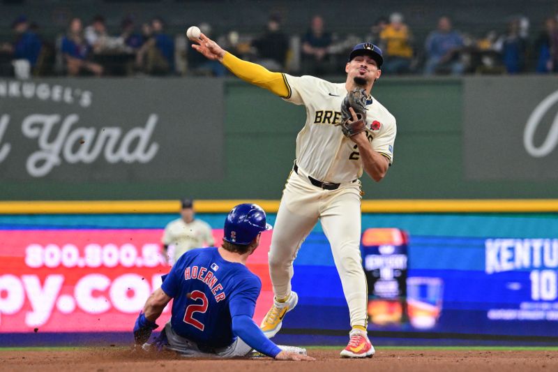 May 27, 2024; Milwaukee, Wisconsin, USA; Milwaukee Brewers shortstop Willy Adames (27) forces out Chicago Cubs second baseman Nico Hoerner (2) in the fourth inning at American Family Field. Mandatory Credit: Benny Sieu-USA TODAY Sports