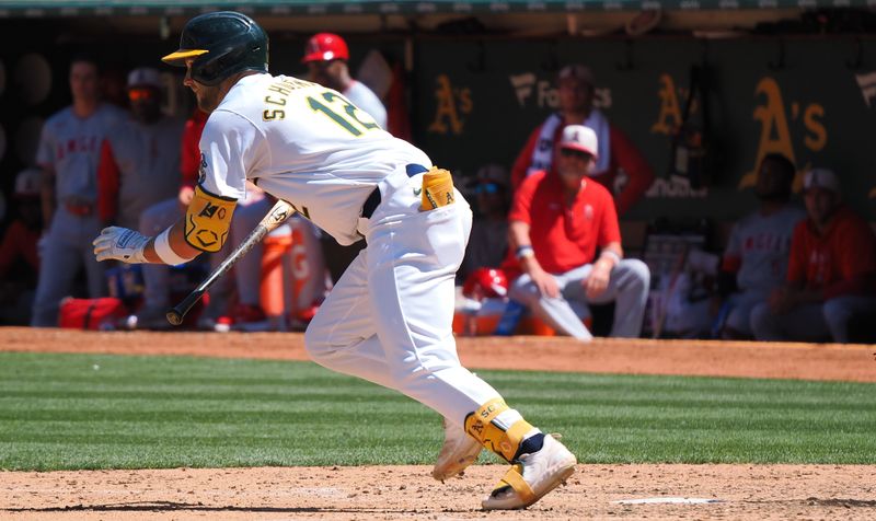 Jul 4, 2024; Oakland, California, USA; Oakland Athletics shortstop Max Shuemann (12) on a sacrifice bunt to send in a run against the Los Angeles Angels during the sixth inning at Oakland-Alameda County Coliseum. Mandatory Credit: Kelley L Cox-USA TODAY Sports