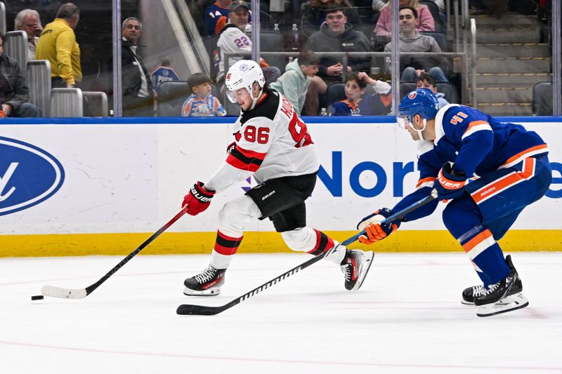 Mar 24, 2024; Elmont, New York, USA;  New Jersey Devils center Jack Hughes (86) attempts a back hand shot defended by New York Islanders defenseman Robert Bortuzzo (41) during the third period at UBS Arena. Mandatory Credit: Dennis Schneidler-USA TODAY Sports