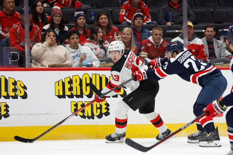 Feb 20, 2024; Washington, District of Columbia, USA; New Jersey Devils defenseman Luke Hughes (43) skates with the puck as Washington Capitals center Michael Sgarbossa (23) defends in the first period at Capital One Arena. Mandatory Credit: Geoff Burke-USA TODAY Sports