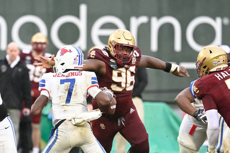 Dec 28, 2023; Boston, MA, USA; Boston College Eagles defensive tackle Cam Horsley (96) reaches out for Southern Methodist Mustangs quarterback Kevin Jennings (7) during the second half at Fenway Park. Mandatory Credit: Eric Canha-USA TODAY Sports