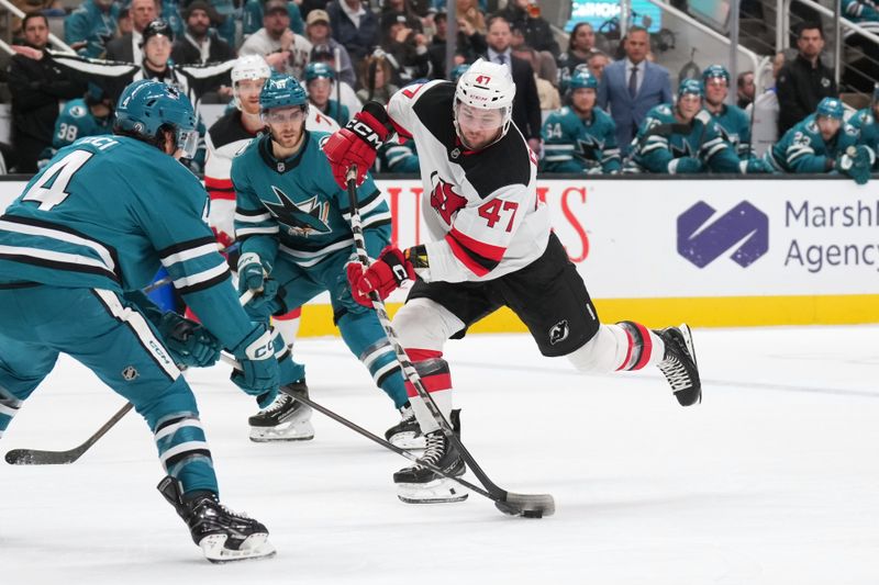 Jan 4, 2025; San Jose, California, USA; New Jersey Devils center Paul Cotter (47) shoots against San Jose Sharks defenseman Cody Ceci (4) during the first period at SAP Center at San Jose. Mandatory Credit: Darren Yamashita-Imagn Images