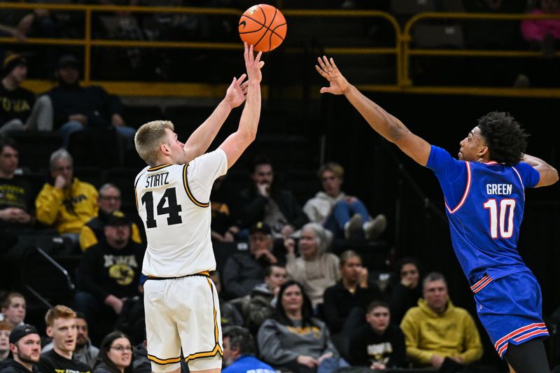 Dec 29, 2025; Iowa City, Iowa, USA; Iowa Hawkeyes guard Bennett Stirtz (14) shoots a three point basket as UMass Lowell River Hawks forward Austin Green (10) defends during the first half at Carver-Hawkeye Arena. Mandatory Credit: Jeffrey Becker-Imagn Images
