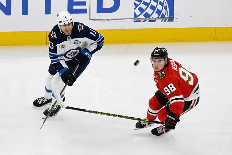 Jan 19, 2026; Chicago, Illinois, USA;  Winnipeg Jets center Gabriel Vilardi (13) plays the puck against Chicago Blackhawks center Connor Bedard (98) during the third period at United Center. Mandatory Credit: Matt Marton-Imagn Images