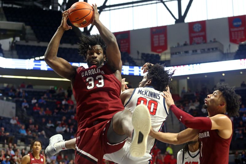 Feb 11, 2023; Oxford, Mississippi, USA; South Carolina Gamecocks forward Josh Gray (33) collects a rebound over Mississippi Rebels forward Jayveous McKinnis (0) during the second half at The Sandy and John Black Pavilion at Ole Miss. Mandatory Credit: Petre Thomas-USA TODAY Sports