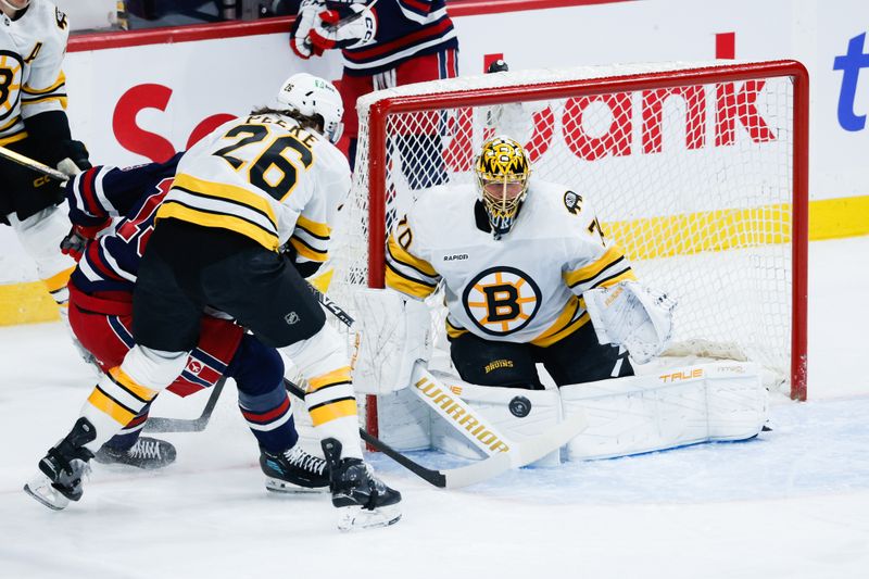 Dec 11, 2025; Winnipeg, Manitoba, CAN; Boston Bruins goalie Joonas Jorpisalo (70) makes a save on Winnipeg Jets forward Gabriel Vilardi (13) looks for a rebound during the first period at Canada Life Centre.  Mandatory Credit: Terrence Lee-Imagn Images