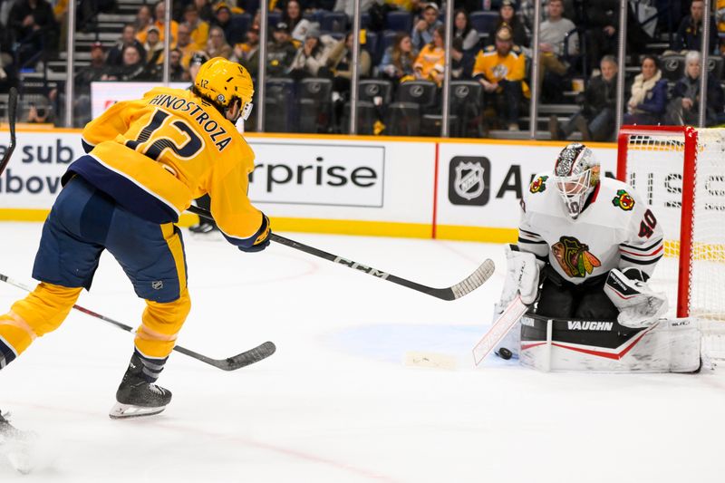 Jan 16, 2025; Nashville, Tennessee, USA;  Chicago Blackhawks goaltender Arvid Soderblom (40) blocks the shot of Nashville Predators center Vinnie Hinostroza (12) during the third period at Bridgestone Arena. Mandatory Credit: Steve Roberts-Imagn Images