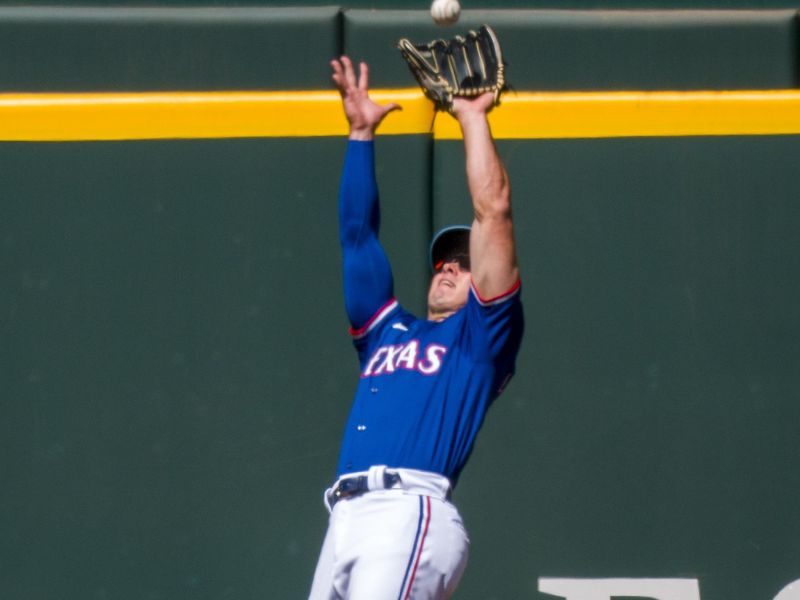 Mar 26, 2024; Arlington, Texas, USA; Texas Rangers left field Wyatt Langford (82) leaps to catch a fly ball hit by Boston Red Sox center fielder Ceddanne Rafaela (not pictured) during the fourth inning at Globe Life Field. Mandatory Credit: Jerome Miron-USA TODAY Sports