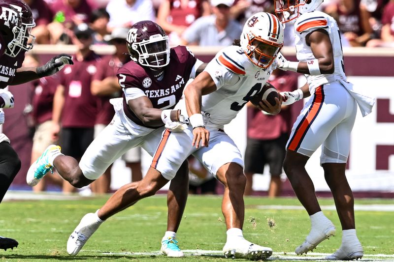 Sep 23, 2023; College Station, Texas, USA; Auburn Tigers quarterback Robby Ashford (9) runs the ball during the third quarter as Texas A&M Aggies defensive back Jacoby Mathews (2) attempts to tackle him at Kyle Field. Mandatory Credit: Maria Lysaker-USA TODAY Sports