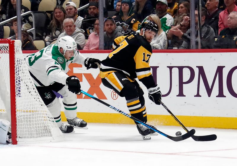 Oct 24, 2023; Pittsburgh, Pennsylvania, USA; Pittsburgh Penguins right wing Bryan Rust (17) moves the puck against Dallas Stars defenseman Esa Lindell (23) during the first period at PPG Paints Arena. Mandatory Credit: Charles LeClaire-USA TODAY Sports