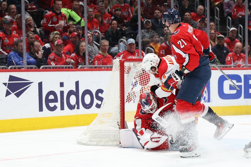 Feb 25, 2025; Washington, District of Columbia, USA; Calgary Flames defenseman Rasmus Andersson (4) crashes into Washington Capitals goaltender Logan Thompson (48) while reaching for the puck as Capitals center Aliaksei Protas (21) defends in the second period at Capital One Arena. Mandatory Credit: Geoff Burke-Imagn Images