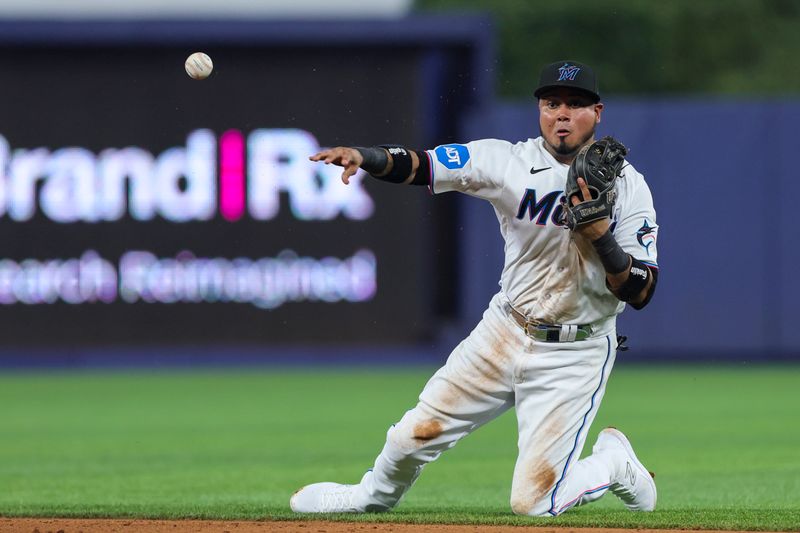 Jul 30, 2023; Miami, Florida, USA; Miami Marlins second baseman Luis Arraez (3) throws to first and retires Detroit Tigers shortstop Javier Baez (not pictured) during the fifth inning at loanDepot Park. Mandatory Credit: Sam Navarro-USA TODAY Sports