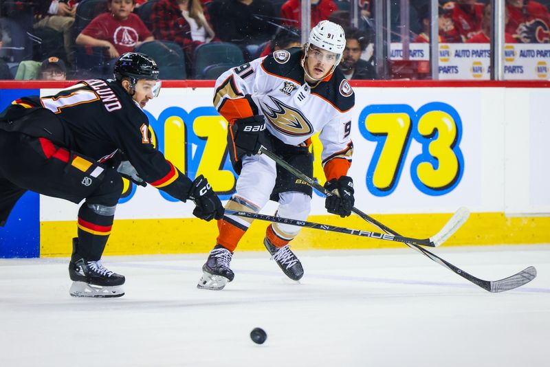 Apr 2, 2024; Calgary, Alberta, CAN; Anaheim Ducks center Leo Carlsson (91) and Calgary Flames center Mikael Backlund (11) battles for the puck during the first period at Scotiabank Saddledome. Mandatory Credit: Sergei Belski-USA TODAY Sports