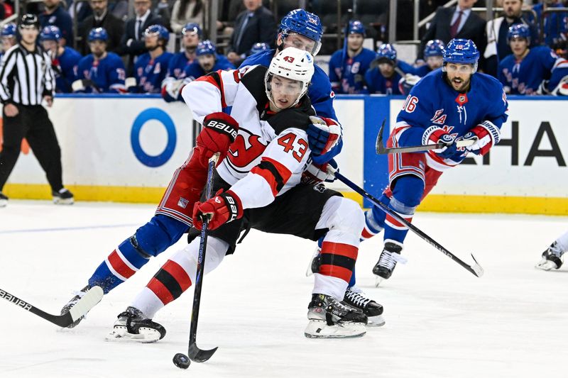 Dec 2, 2024; New York, New York, USA;  New Jersey Devils defenseman Luke Hughes (43) makes a move around New York Rangers right wing Kaapo Kakko (24) during the first period at Madison Square Garden. Mandatory Credit: Dennis Schneidler-Imagn Images