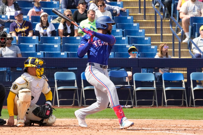 Mar 16, 2024; Phoenix, Arizona, USA; Texas Rangers center fielder Leody Taveras (3) hits a single against the Milwaukee Brewers in the third inning at American Family Fields of Phoenix. Mandatory Credit: Rick Scuteri-USA TODAY Sports