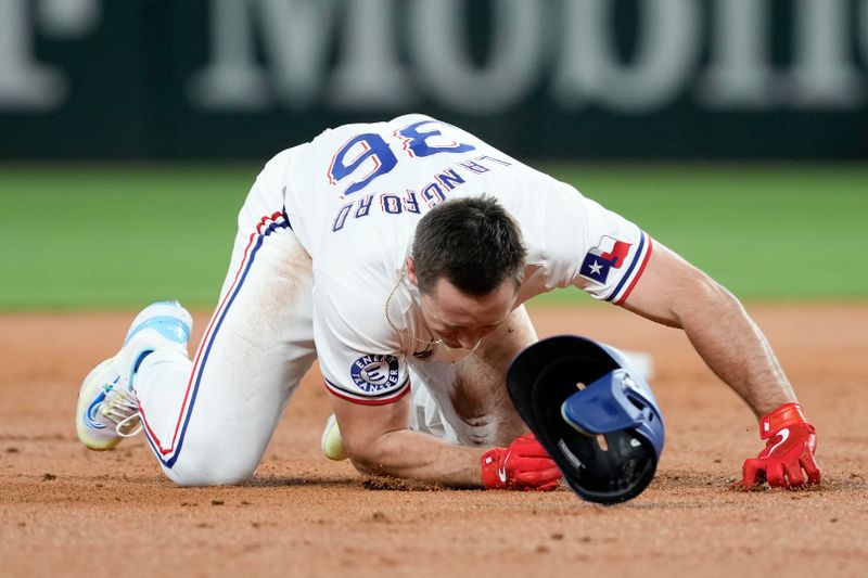 Apr 24, 2024; Arlington, Texas, USA; Texas Rangers designated hitter Wyatt Langford (36) slips and falls after rounding second base on his double against the Seattle Mariners during the second inning at Globe Life Field. Mandatory Credit: Jim Cowsert-USA TODAY Sports