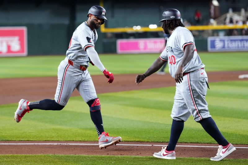 Jun 26, 2024; Phoenix, Arizona, USA; Minnesota Twins shortstop Willi Castro (50) bumps fists with Minnesota Twins third base coach/outfield coach Tommy Watkins (40) after hitting a two run home run against the Arizona Diamondbacks during the fifth inning at Chase Field. Mandatory Credit: Joe Camporeale-USA TODAY Sports