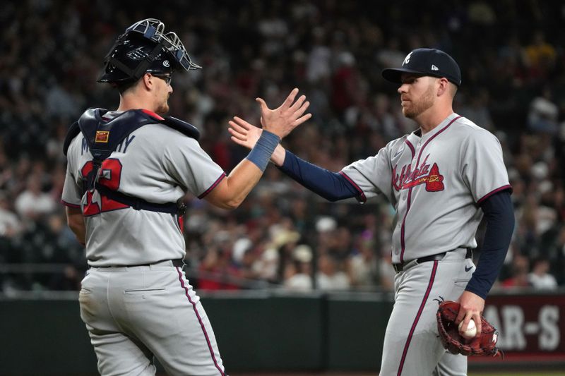 Apr 25, 2025; Phoenix, Arizona, USA; Atlanta Braves catcher Sean Murphy (12) and pitcher Aaron Bummer (49) celebrate after defeating the Arizona Diamondbacks at Chase Field. Mandatory Credit: Rick Scuteri-Imagn Images