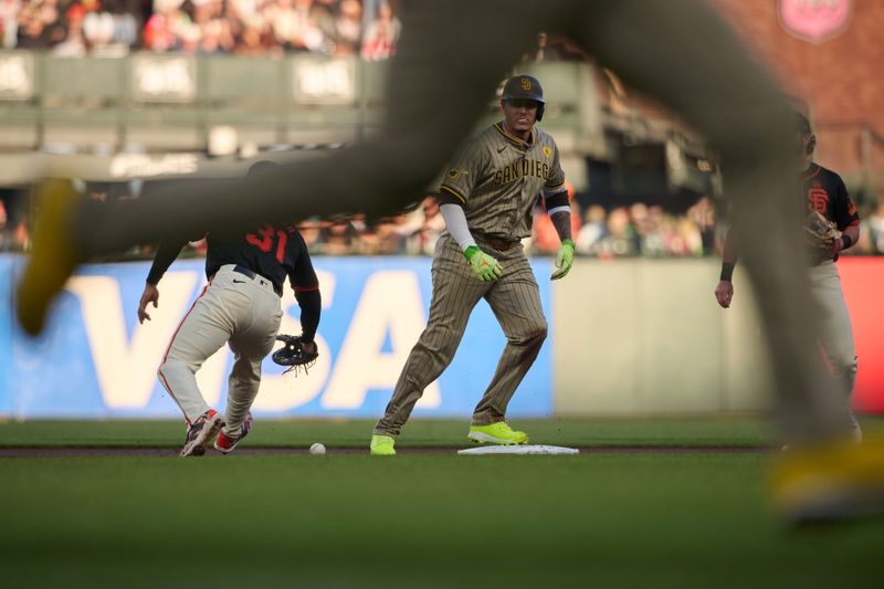 Sep 14, 2024; San Francisco, California, USA; San Diego Padres infielder Manny Machado (13) stands on second base after hitting a double against the San Francisco Giants during the first inning at Oracle Park. San Diego Padres outfielder Jurickson Profar (10) (obscured) scored a run on a throwing error by San Francisco.  Mandatory Credit: Robert Edwards-Imagn Images