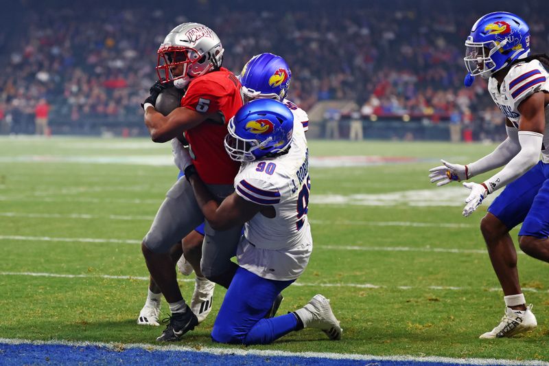 Dec 26, 2023; Phoenix, AZ, USA; UNLV Rebels running back Vincent Davis Jr. (5) runs for the a touchdown against Kansas Jayhawks defensive lineman Jereme Robinson (90) during the second half in the Guaranteed Rate Bowl at Chase Field. Mandatory Credit: Mark J. Rebilas-USA TODAY Sports