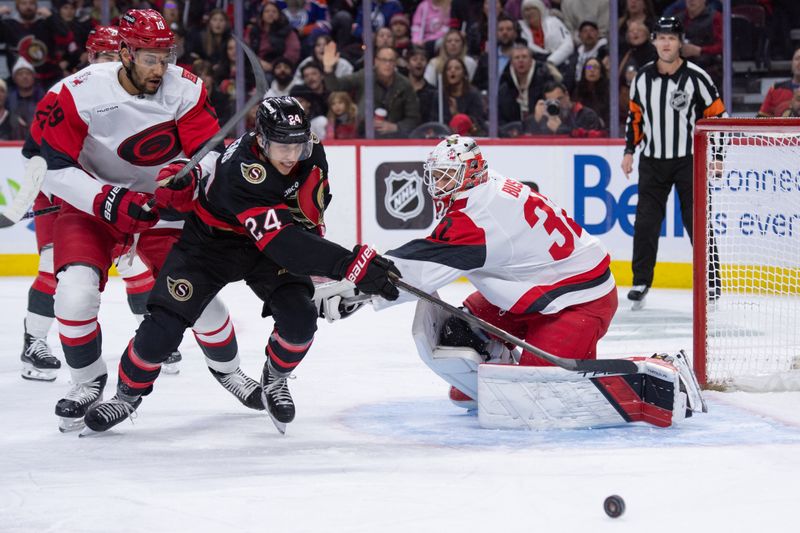 Jan 24, 2026; Ottawa, Ontario, CAN; Ottawa Senators center Dylan Cozens (24) chases the puck after being blocked by Carolina Hurricanes defenseman K'Andre Miller (19) while attempting a shot on goalie Brandon Bussi (32) in the first period at the Canadian Tire Centre. Mandatory Credit: Marc DesRosiers-IMAGN Images
