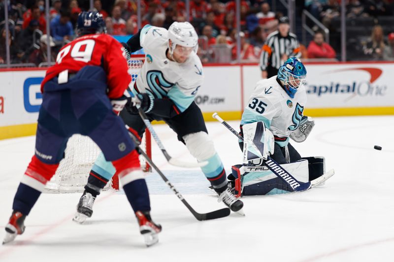 Jan 11, 2024; Washington, District of Columbia, USA; Seattle Kraken goaltender Joey Daccord (35) makes a save as Washington Capitals center Hendrix Lapierre (29) and Kraken defenseman Brian Dumoulin (8) look on in the third period at Capital One Arena. Mandatory Credit: Geoff Burke-USA TODAY Sports