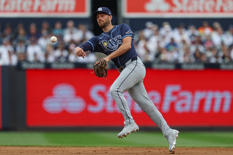May 4, 2025; Bronx, New York, USA; Tampa Bay Rays second baseman Brandon Lowe (8) throws the ball to first base for an out during the second inning against the New York Yankees at Yankee Stadium. Mandatory Credit: Vincent Carchietta-Imagn Images