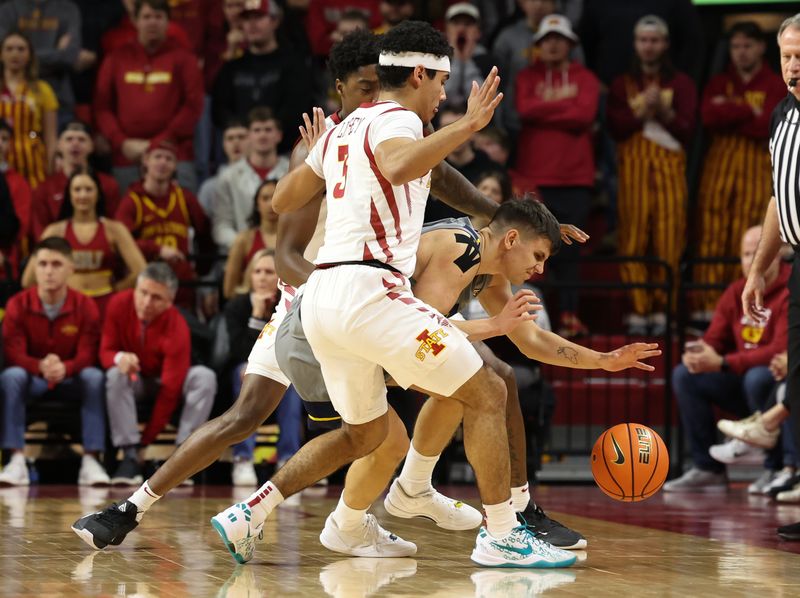 Feb 24, 2024; Ames, Iowa, USA; West Virginia Mountaineers guard Kerr Kriisa (3) is defended by Iowa State Cyclones guard Tamin Lipsey (3) and Iowa State Cyclones forward Hason Ward (24) during the first half at James H. Hilton Coliseum. Mandatory Credit: Reese Strickland-USA TODAY Sports