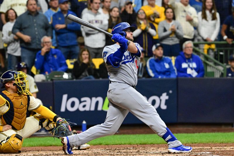 Oct 14, 2025; Milwaukee, Wisconsin, USA; Los Angeles Dodgers third baseman Max Muncy (13) hits a solo home run against the Milwaukee Brewers in the sixth inning during game two of the NLCS round for the 2025 MLB playoffs at American Family Field. Mandatory Credit: Benny Sieu-Imagn Images