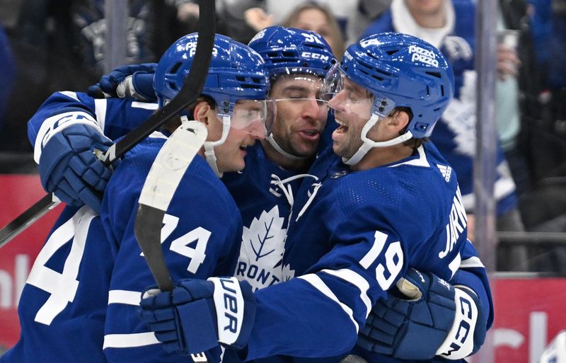 Mar 2, 2024; Toronto, Ontario, CAN;  Toronto Maple Leafs forward John Tavares (91) celebrates with forwards Bobby McMann (74) and Calle Jarnkrok (19) after scoring against the New York Rangers in the third period at Scotiabank Arena. Mandatory Credit: Dan Hamilton-USA TODAY Sports