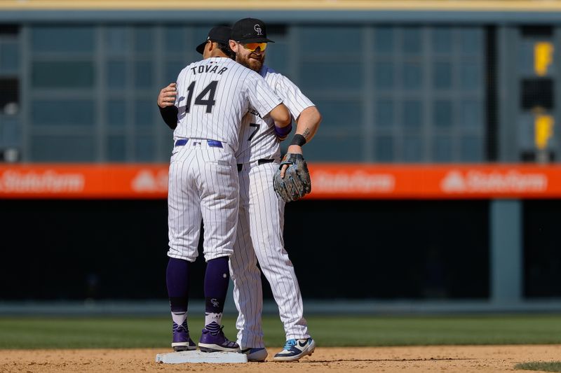 May 27, 2024; Denver, Colorado, USA; Colorado Rockies shortstop Ezequiel Tovar (14) and second baseman Brendan Rodgers (7) celebrate after the game against the Cleveland Guardians at Coors Field. Mandatory Credit: Isaiah J. Downing-USA TODAY Sports