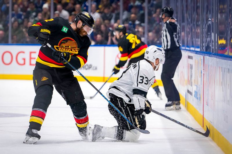 Mar 25, 2024; Vancouver, British Columbia, CAN;  Vancouver Canucks defenseman Ian Cole (82) battles with Los Angeles Kings forward Viktor Arvidsson (33) in the second period at Rogers Arena. Mandatory Credit: Bob Frid-USA TODAY Sports