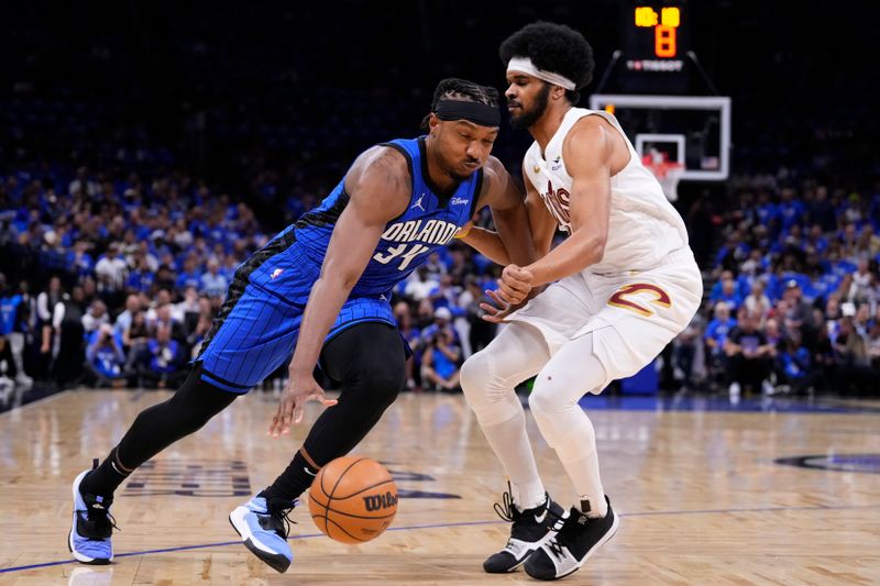 ORLANDO, FLORIDA - APRIL 25: Wendell Carter Jr. #34 of the Orlando Magic dribbles the ball against Jarrett Allen #31 of the Cleveland Cavaliers during the first quarter of game three of the Eastern Conference First Round Playoffs at Kia Center on April 25, 2024 in Orlando, Florida. NOTE TO USER: User expressly acknowledges and agrees that, by downloading and or using this photograph, User is consenting to the terms and conditions of the Getty Images License Agreement. (Photo by Rich Storry/Getty Images)