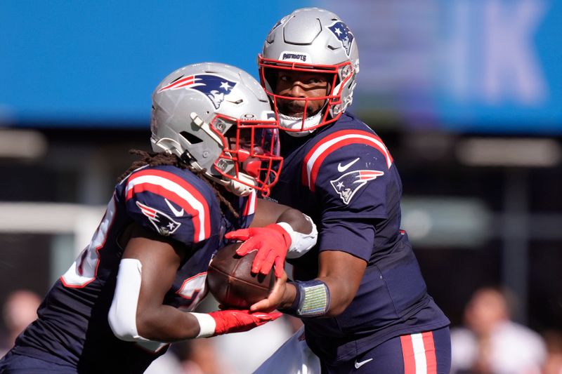 New England Patriots quarterback Jacoby Brissett (7) hands off to running back Rhamondre Stevenson during the first half of an NFL football game against the Miami Dolphins, Sunday, Oct. 6, 2024, in Foxborough, Mass. (AP Photo/Steven Senne)