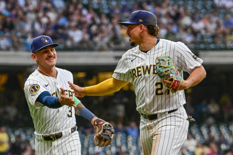 Sep 28, 2024; Milwaukee, Wisconsin, USA; Milwaukee Brewers shortstop Willy Adames (27) reacts with third baseman Joey Ortiz (3) after making a play in the first inning against the New York Mets at American Family Field. Mandatory Credit: Benny Sieu-Imagn Images