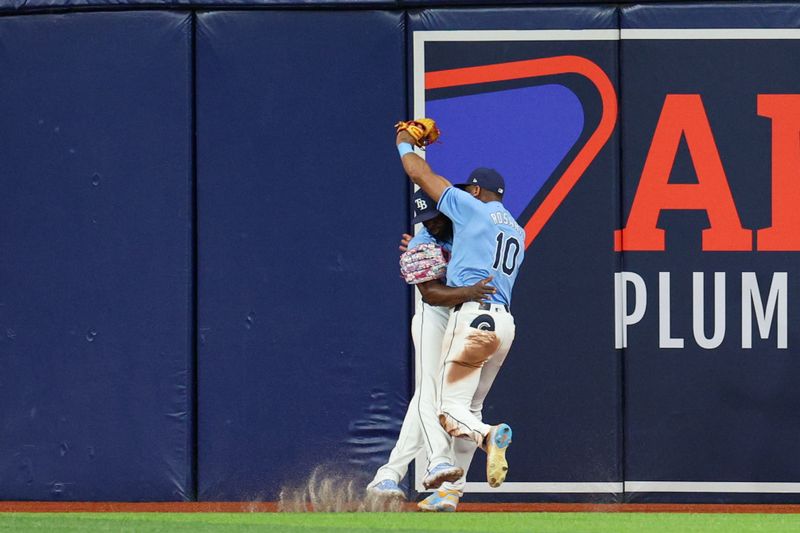 Apr 24, 2024; St. Petersburg, Florida, USA;  Tampa Bay Rays outfielder Amed Rosario (10) collides with outfielder Randy Arozarena (56) after making a catch against the Detroit Tigers in the fifth inning at Tropicana Field. Mandatory Credit: Nathan Ray Seebeck-USA TODAY Sports